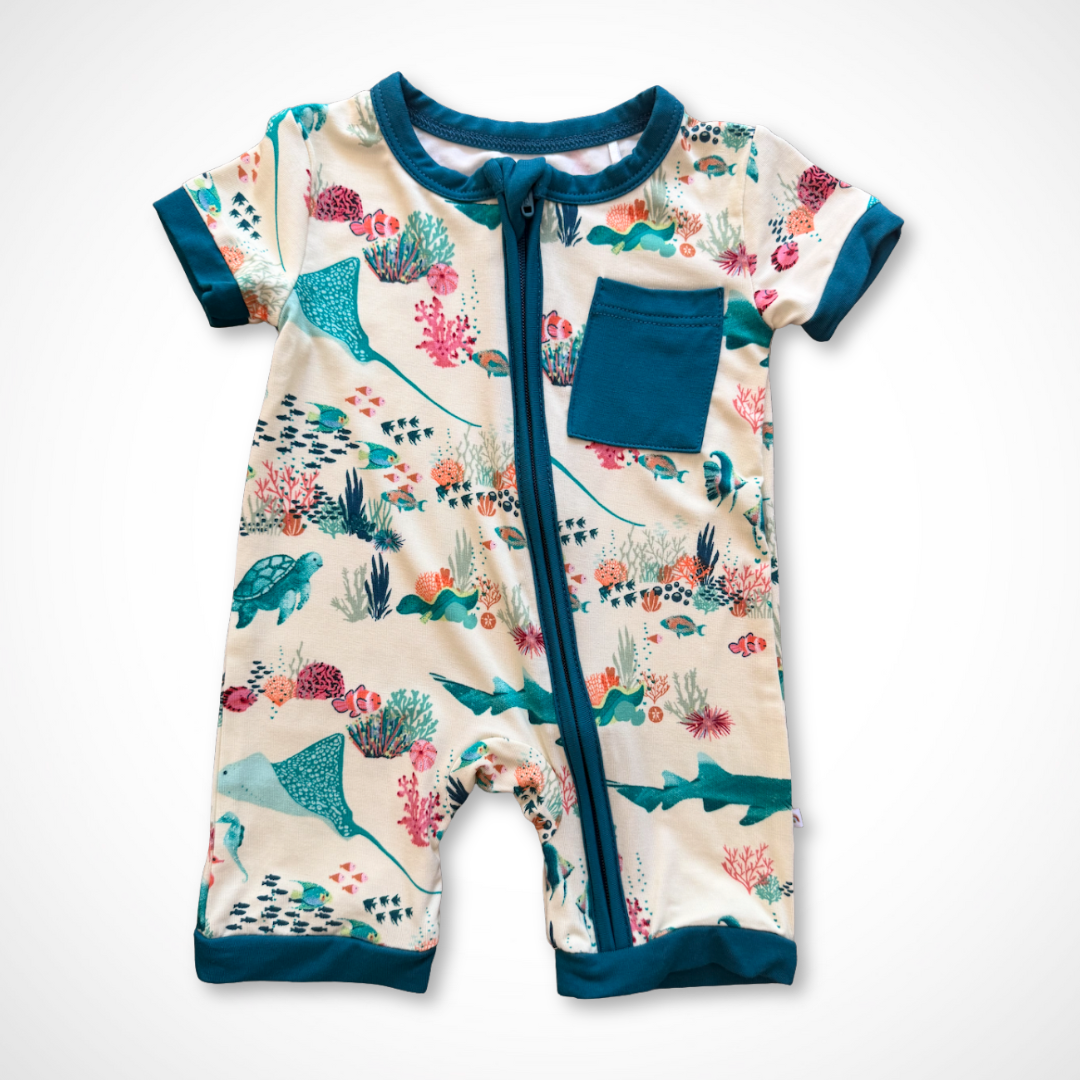 Baby bamboo romper with shark and coral design on a white background