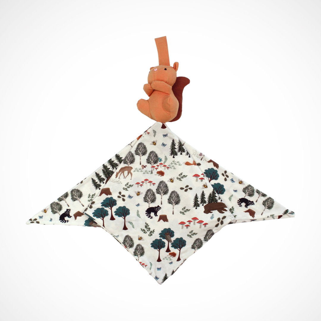 Baby comfort blanket with forest inspired print and squirrel toy on a white background